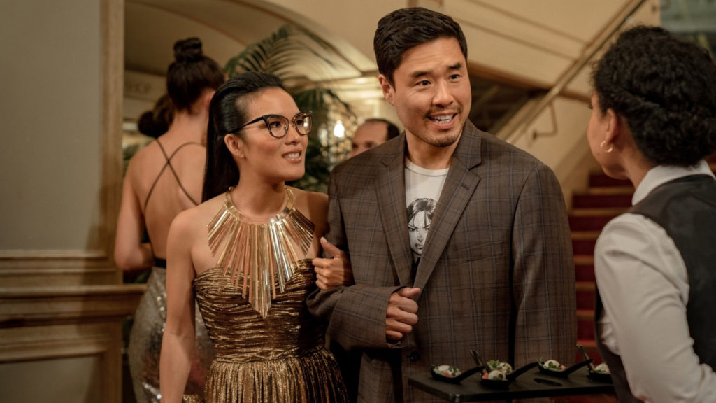 Man and woman in party-wear talking to a waitress